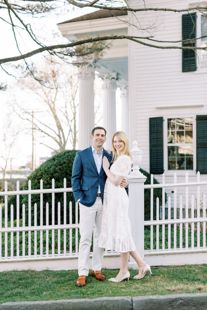 bride and groom in front of white building