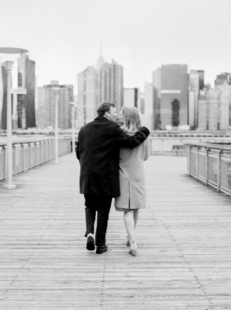 kiss while walking out to the docks at gantry park engagement session