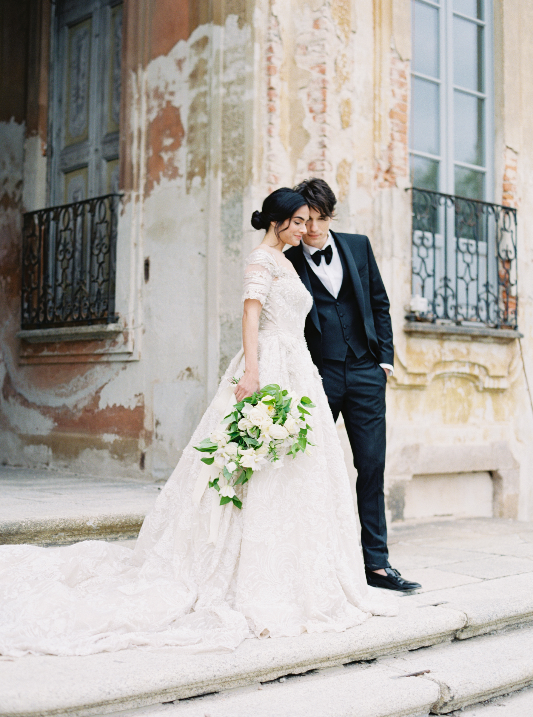 bride and groom whisper outside of villa arconati