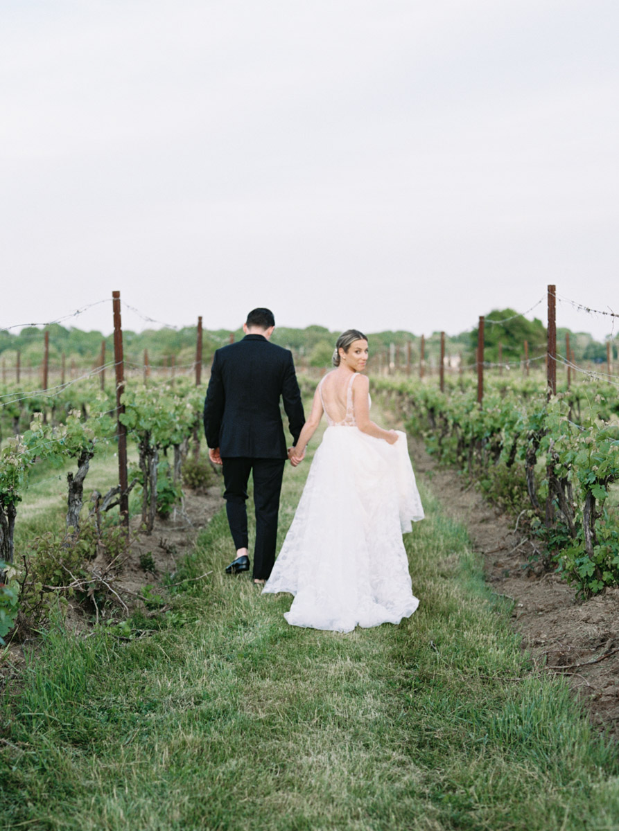 bride and groom walking in the vineyard