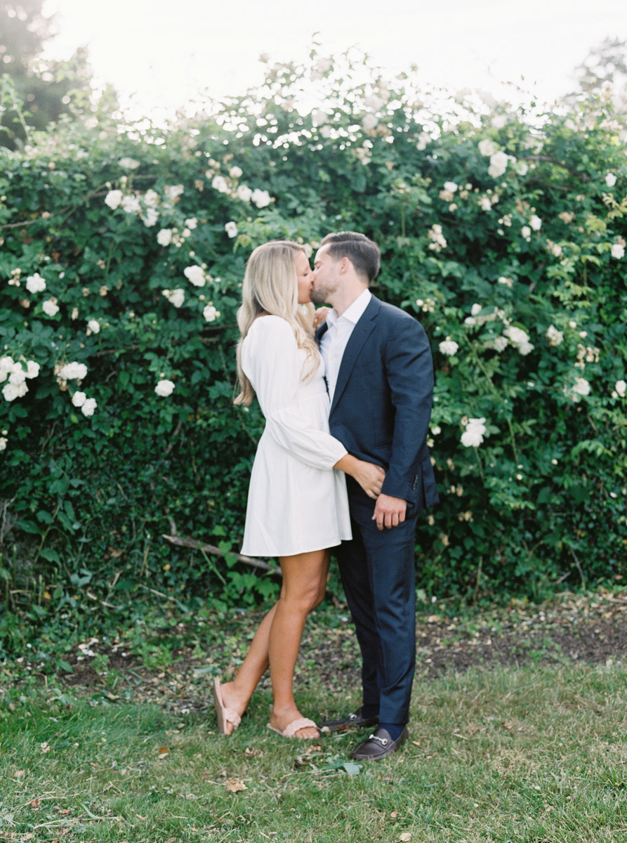 kissing with florals behind the couple
