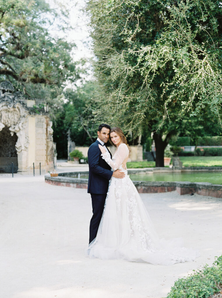 Bride and groom belly button to belly button looking at the camera at their Vizcaya Museum and Gardens Wedding.
