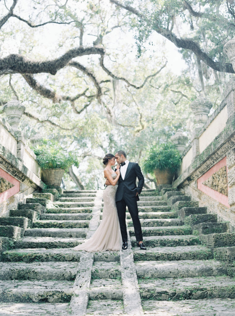 bride and groom embrace on stairs at vizcaya museum and gardens wedding