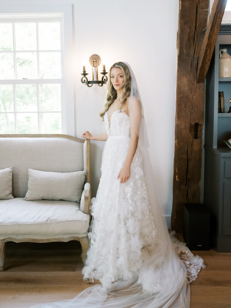 bride standing in her gown in her home getting ready