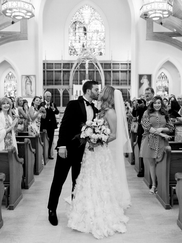 bride and groom aisle kiss at their wedding in the church