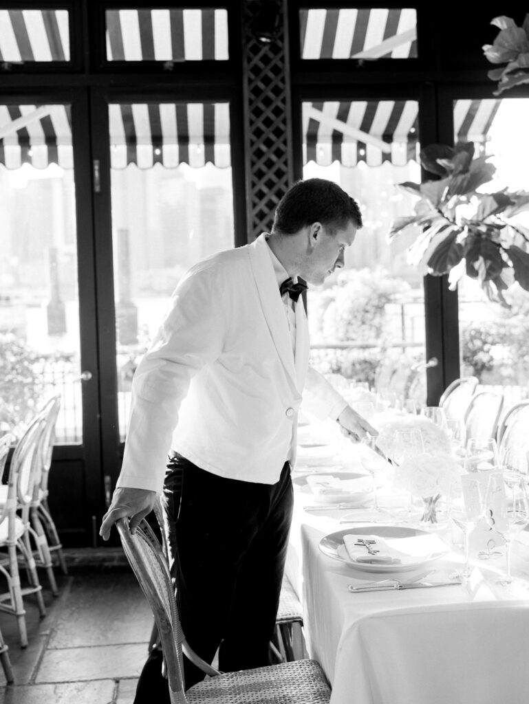 a waiter pouring water at the river cafe