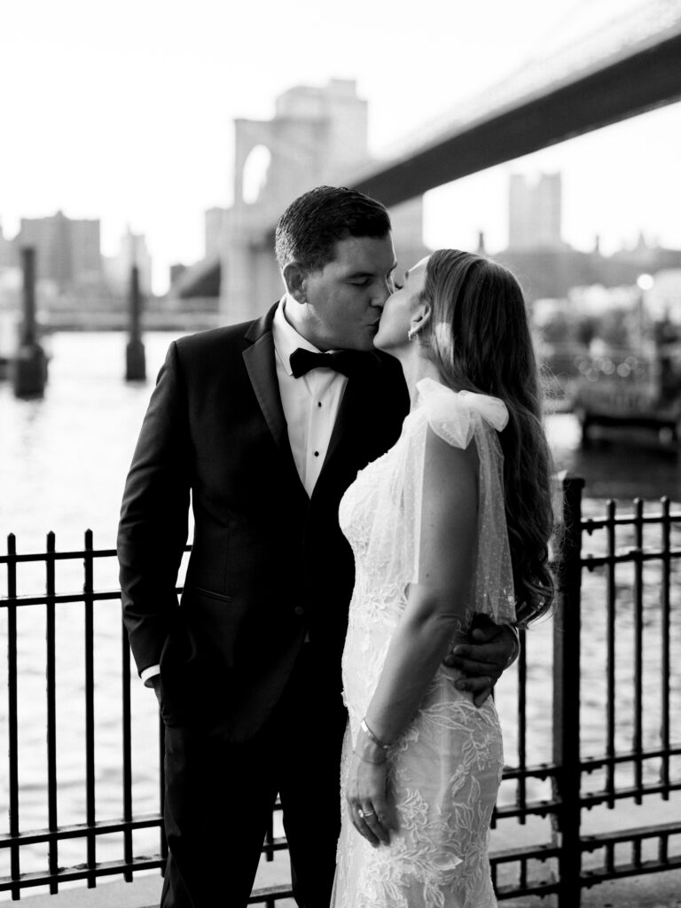 bride and groom kissing under the brooklyn bridge