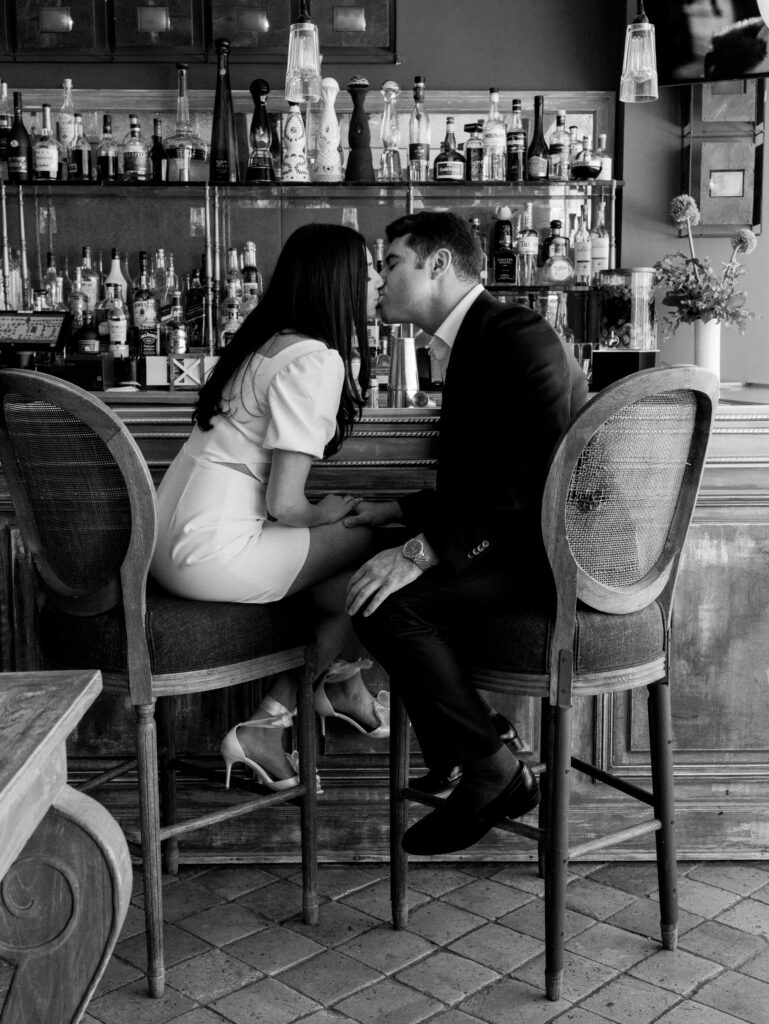 kissing at the bar together during their modern engagement session
