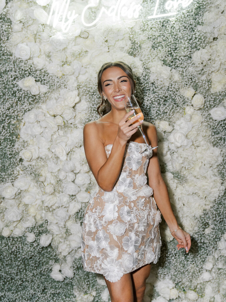 The bride to be enjoying champagne at her photo wall.