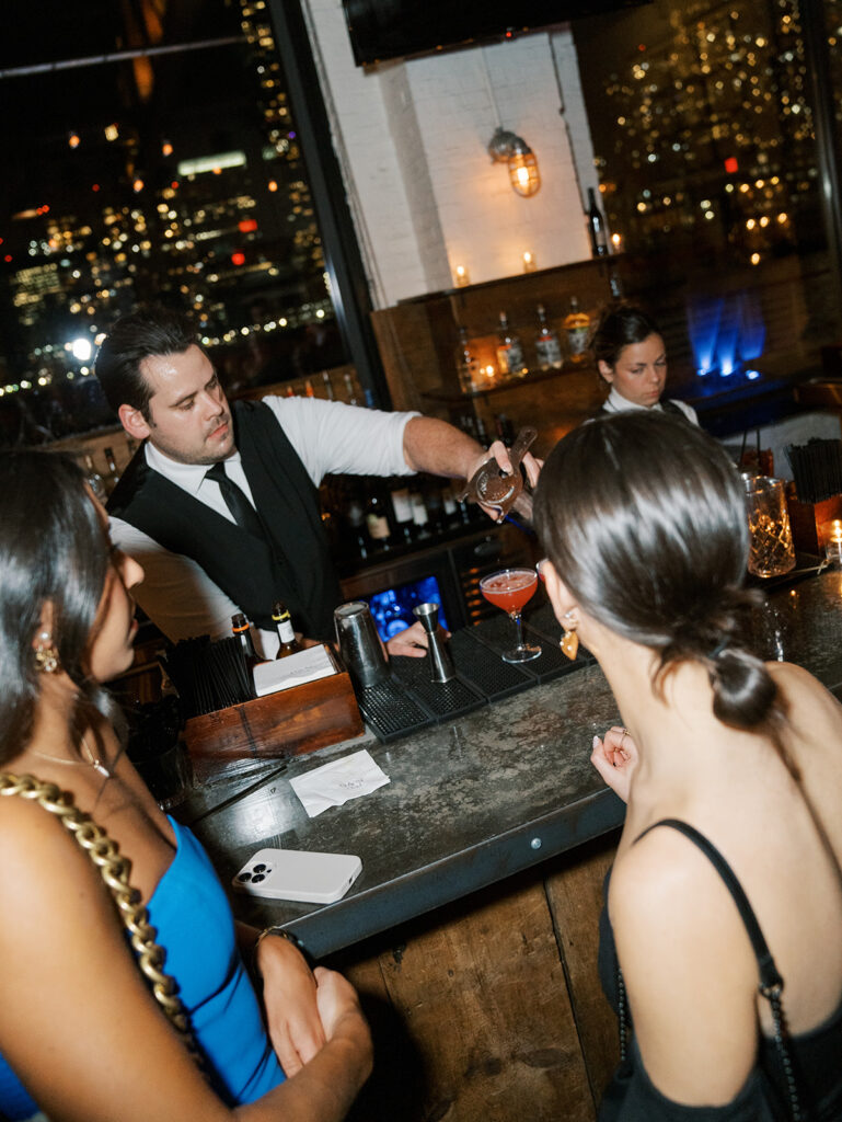 The bartender pouring drinks for guests.