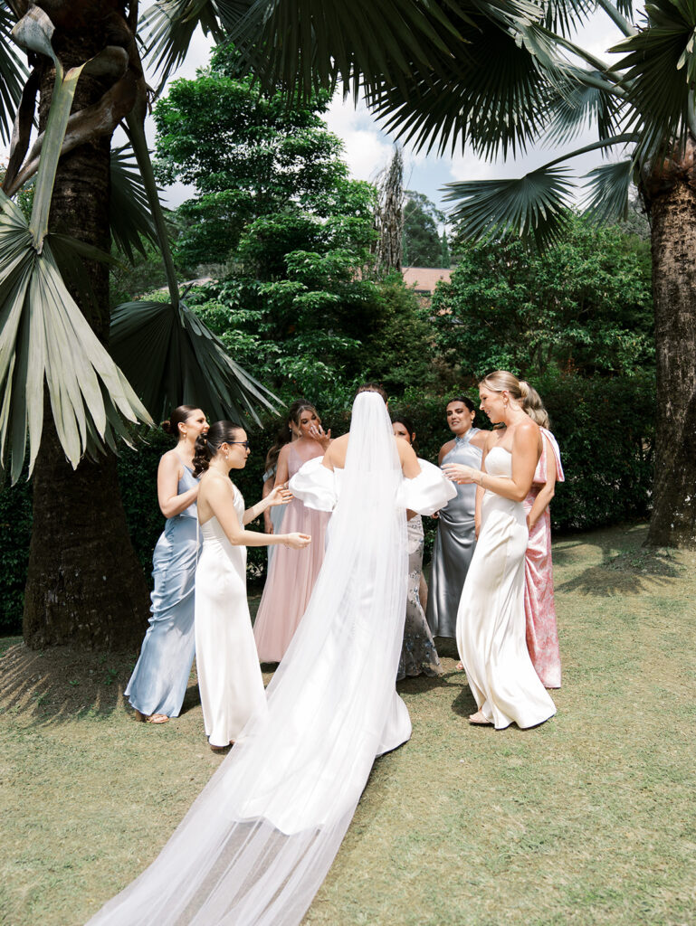 First look with bridesmaids. All the girls are doting over the bride.