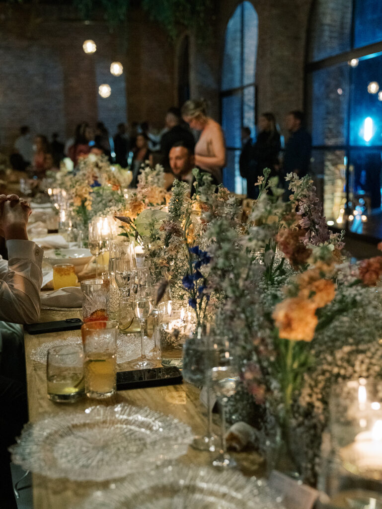 A close up of the tables while guests are mingling around it in the background.