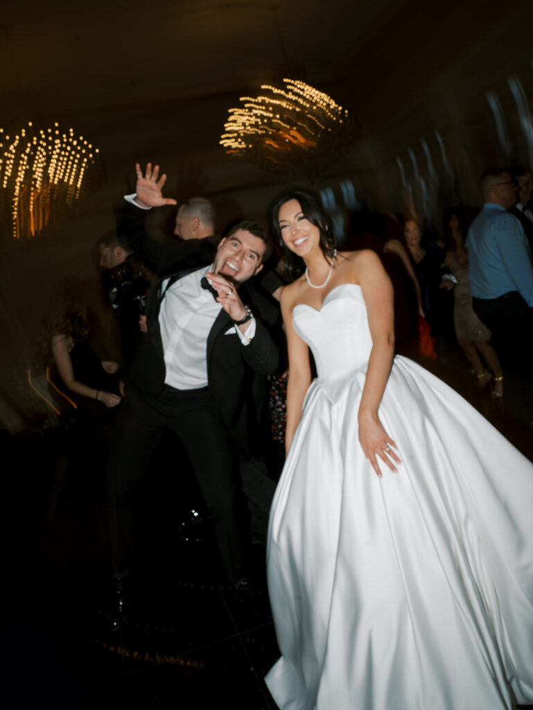 The bride and groom pose for a portrait while dancing during their reception.