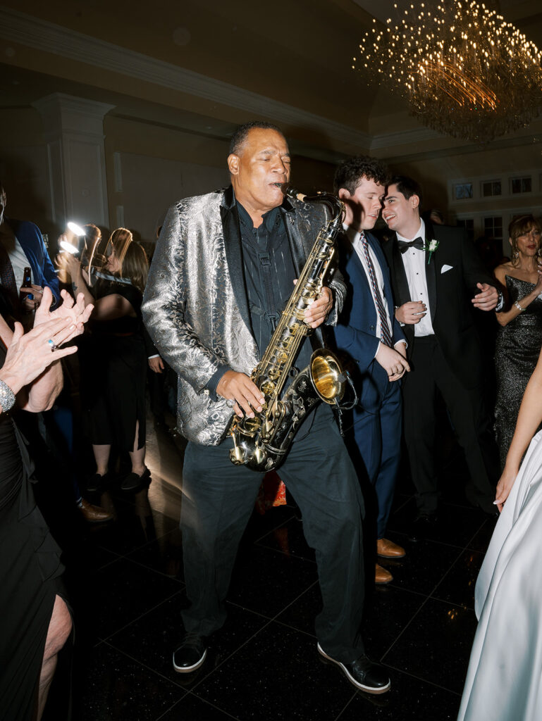 The Band plays saxophone on the dance floor with the guests.