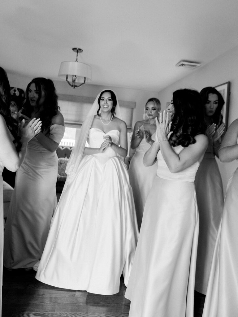 The bride with her bridesmaids when they see her for the first time.