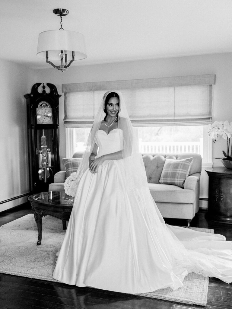 The bride smiling sweetly during her bridal portraits for a full length picture.