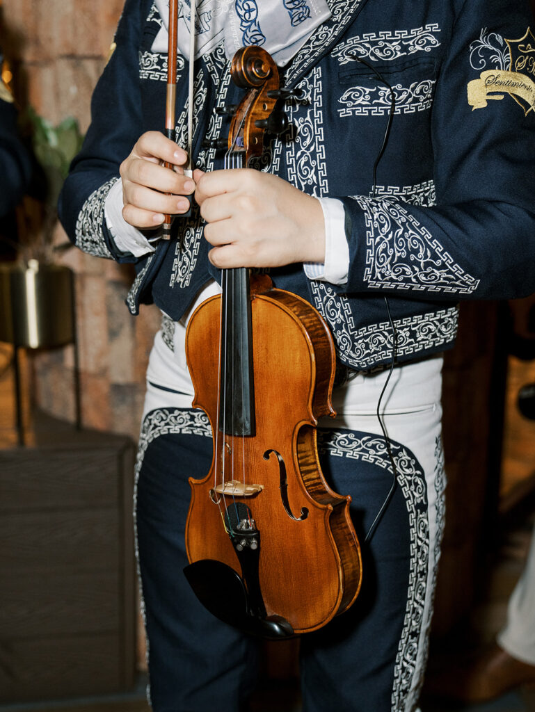 A close up of the mariachi singers at the hotel. Here we can see a violin in his hands.