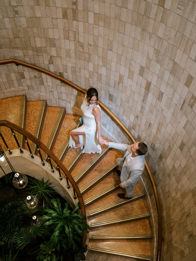 The bride and groom walking up the stairs together. This is a top down view.