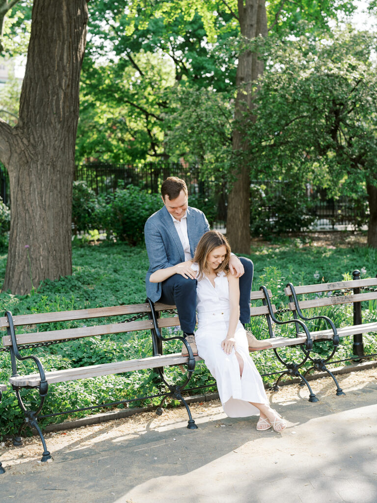 Bride and groom sitting on a bench in Washington Square Park.