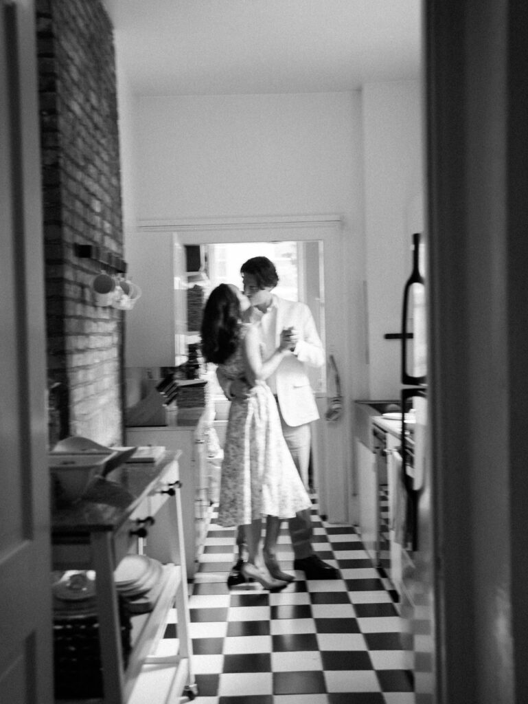 The couple kissing in the kitchen in a blurry action shot.