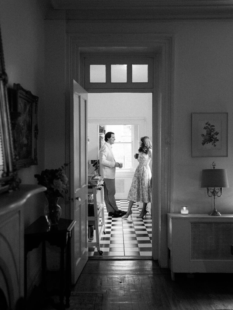 The couple is in the kitchen enjoying a cup of coffee together.