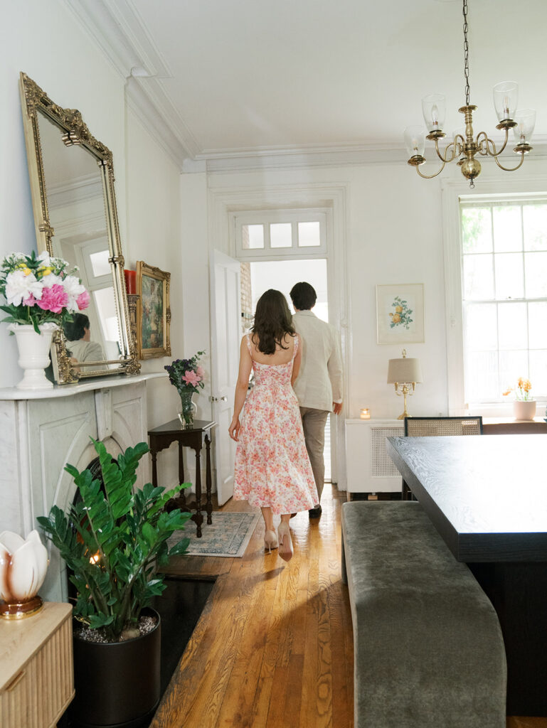 The couple is walking across the dining room together during their West Village Engagement Photos.