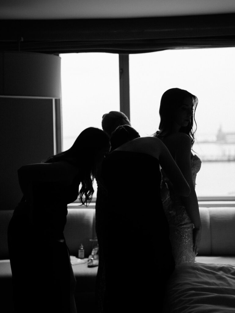 Silhouette portrait of the bride getting married and assisted by her mother.