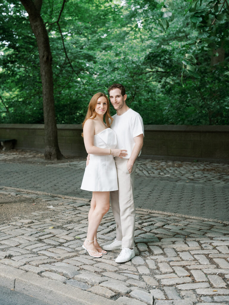 a classic portrait of the bride and groom looking at the camera during their upper east side engagement shoot