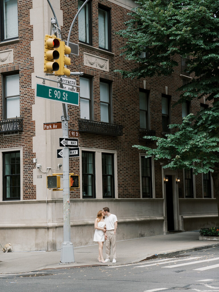 kissing on the street corner during their upper east side engagement shoot