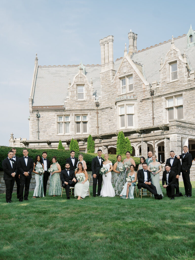 Full wedding party posing for a formal portrait in the lawn at their Castle Wedding at Avery Point