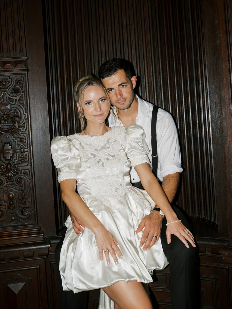 Bride and groom posing for a picture in the bride's mothers wedding gown