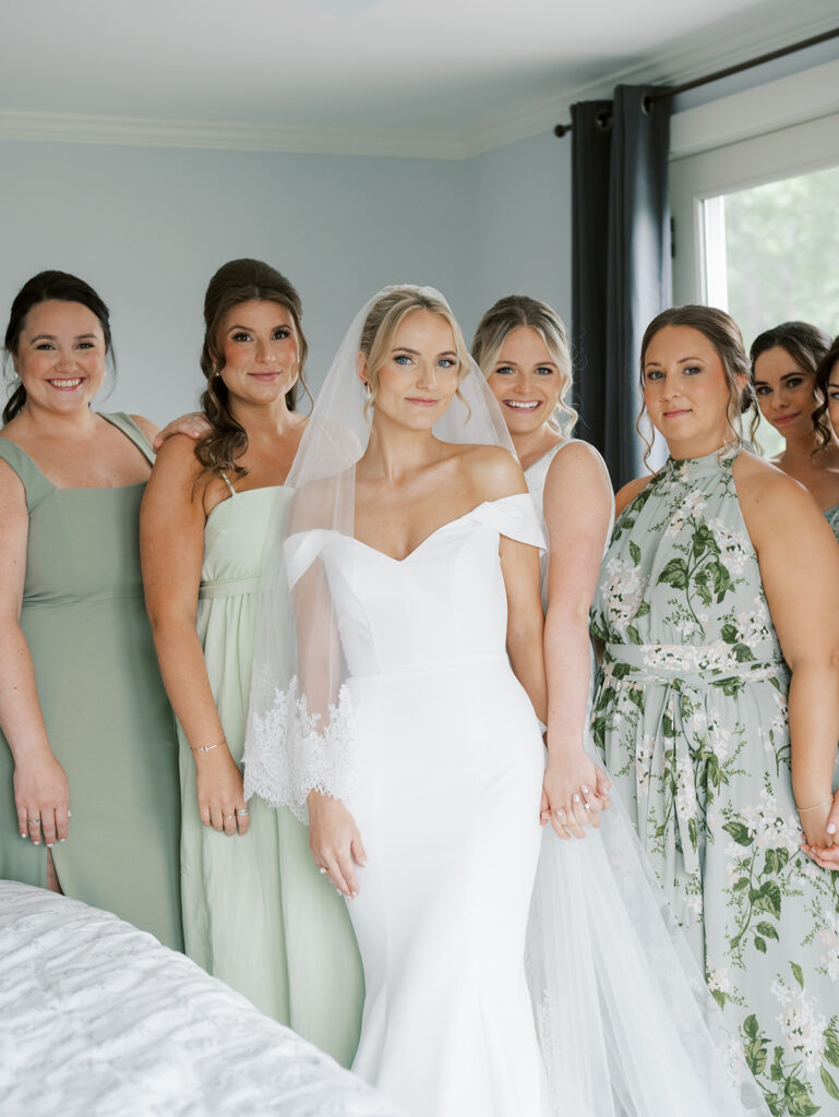 Bride and bridesmaids posing for a portrait looking at the camera