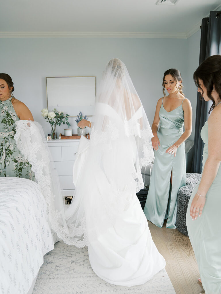 brides maids helping the bride get out the door