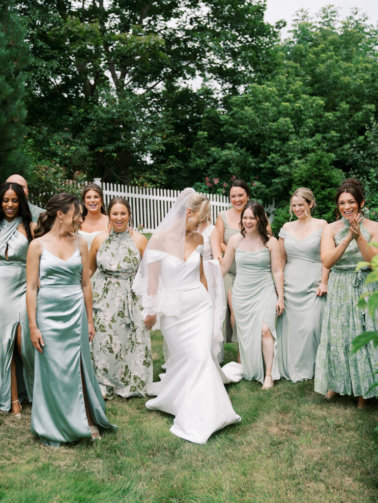 Bridesmaids helping bride walk to the car