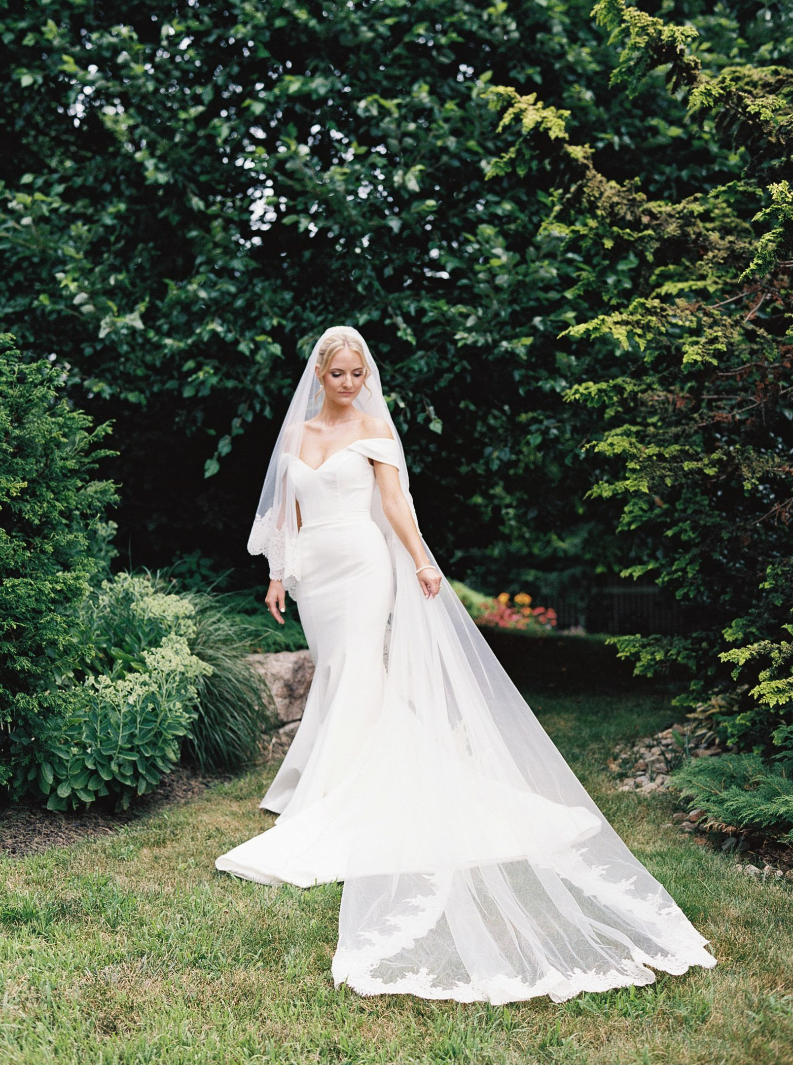 Bride posing in the garden for her portraits all dressed