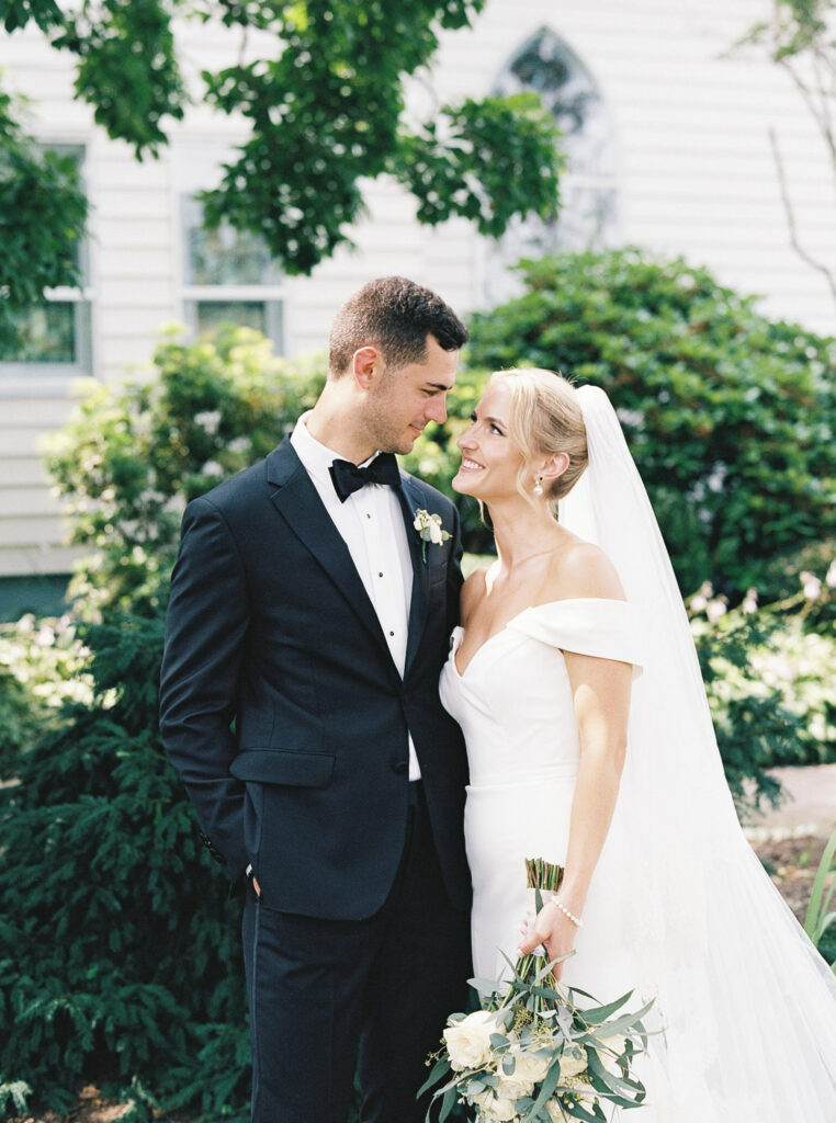 Bride and groom looking at each other in the gardens during their portraits