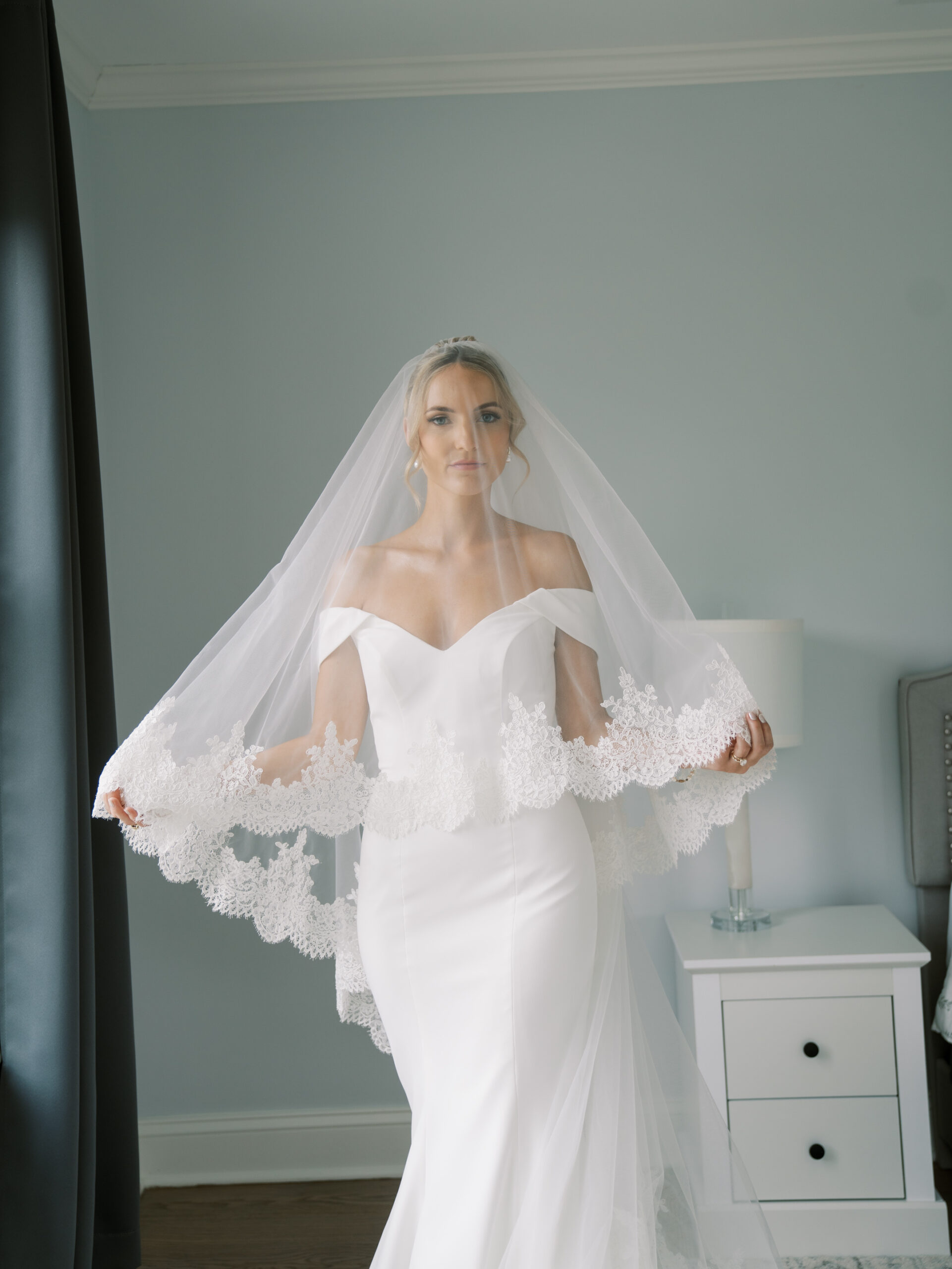 bride holding her veil during her getting ready time for her castle wedding