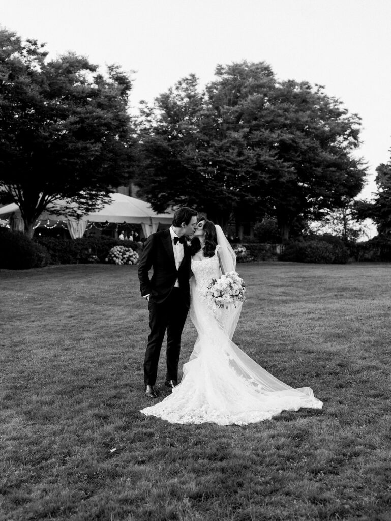 Bride and groom kissing in the field at Eolia Mansion