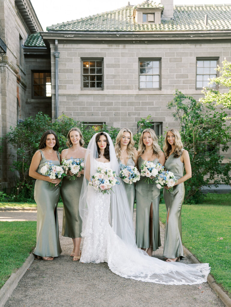 Bridesmaids group picture posing in front of Eolia Mansion