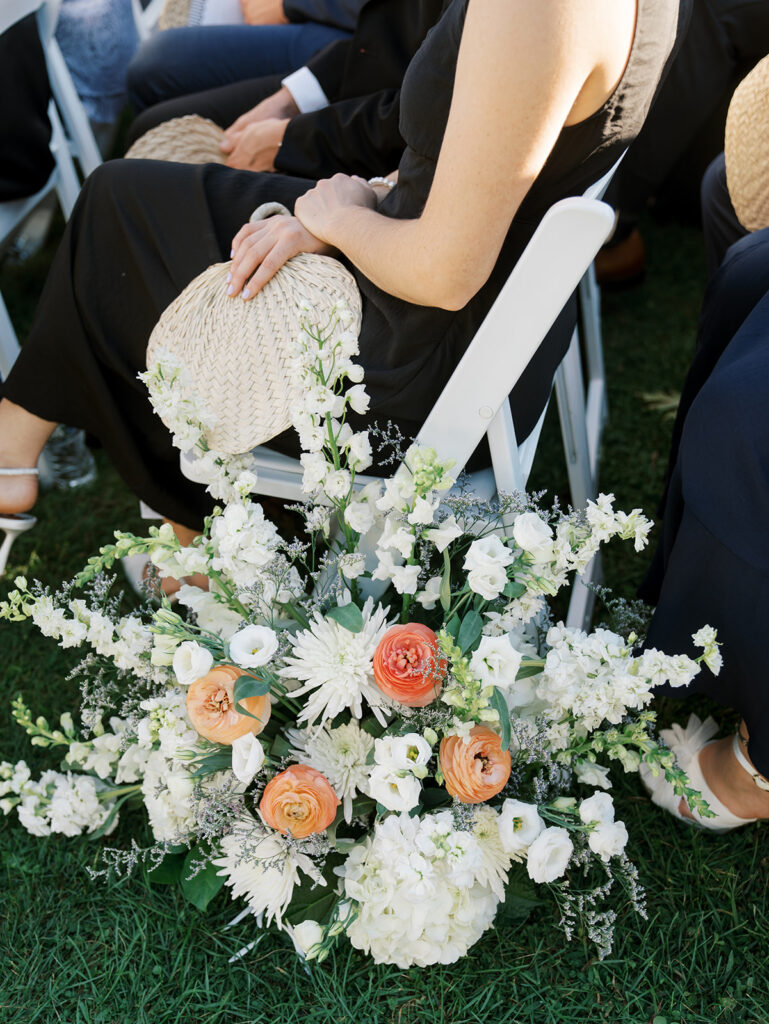 Close up view of the flower arrangements in the aisle with a guest seated.