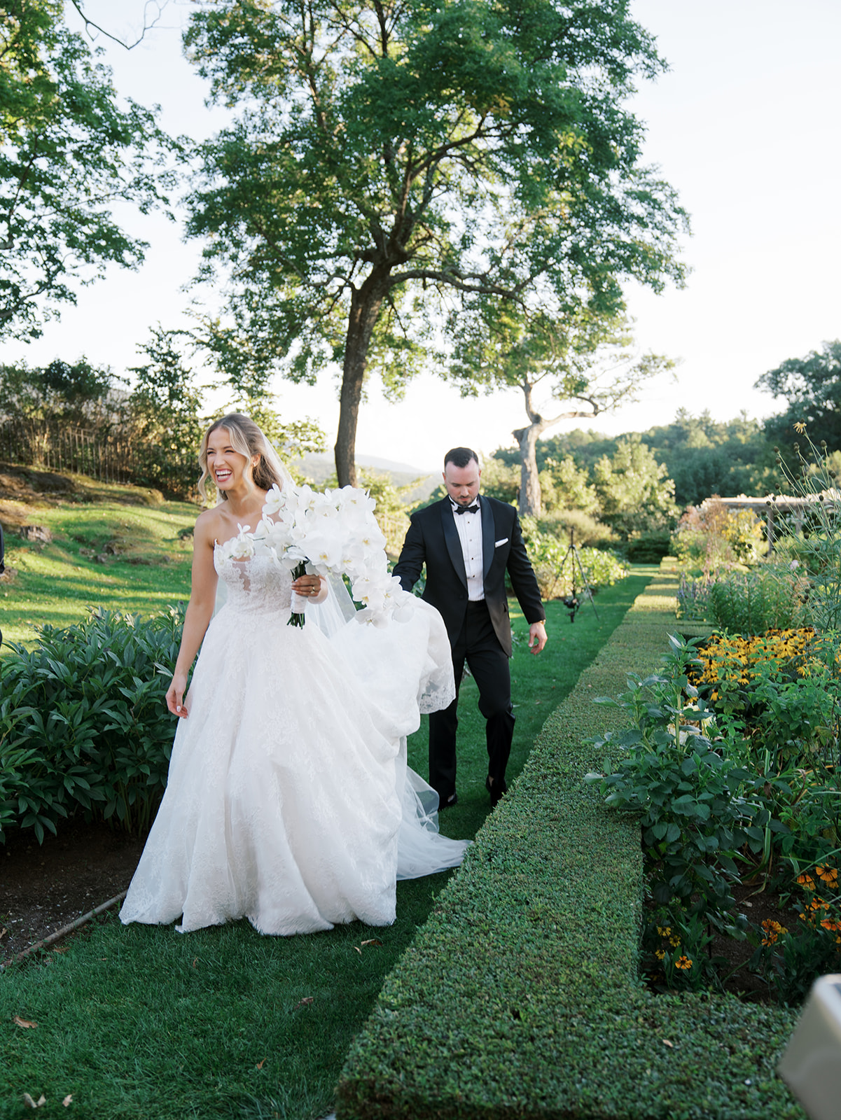 The bride and groom walking in the gardens after their portrait session.