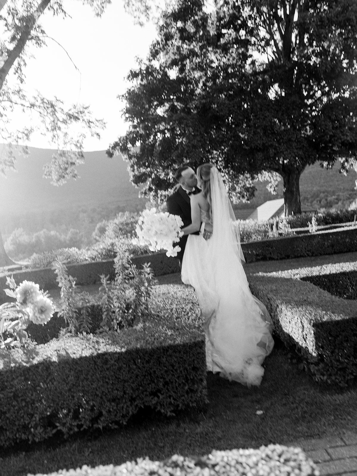 The bride and groom kissing in the gardens at their Hildene Wedding