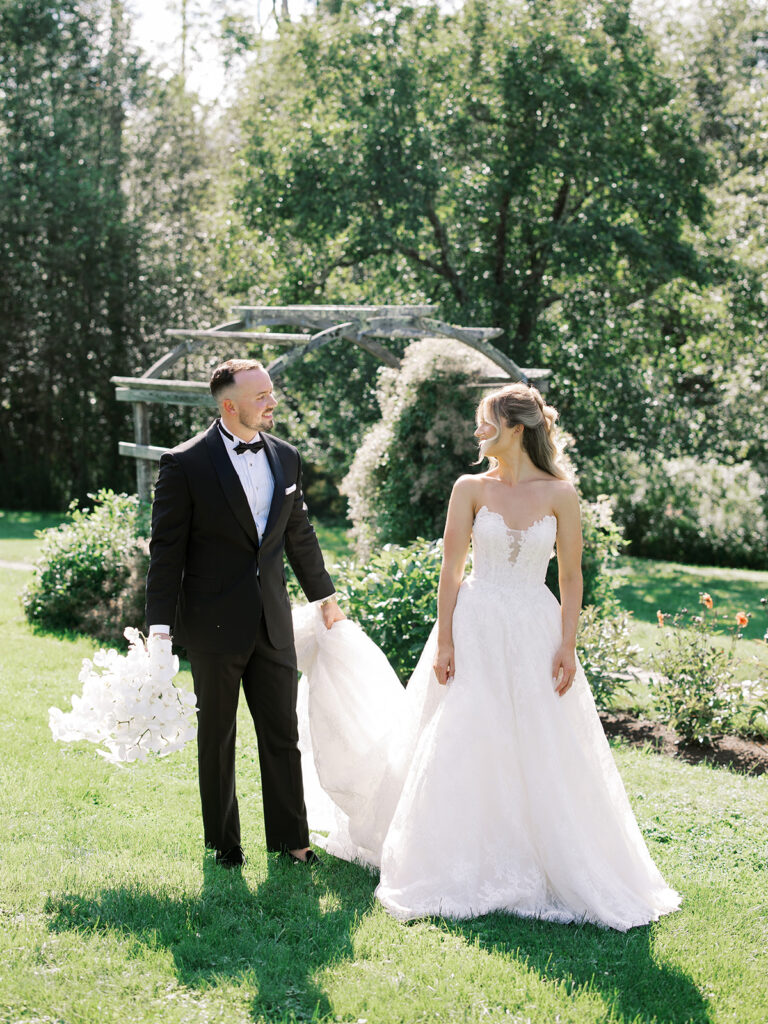 The bride and groom posing for a portrait while walking and looking at each other at the Hildene Wedding.