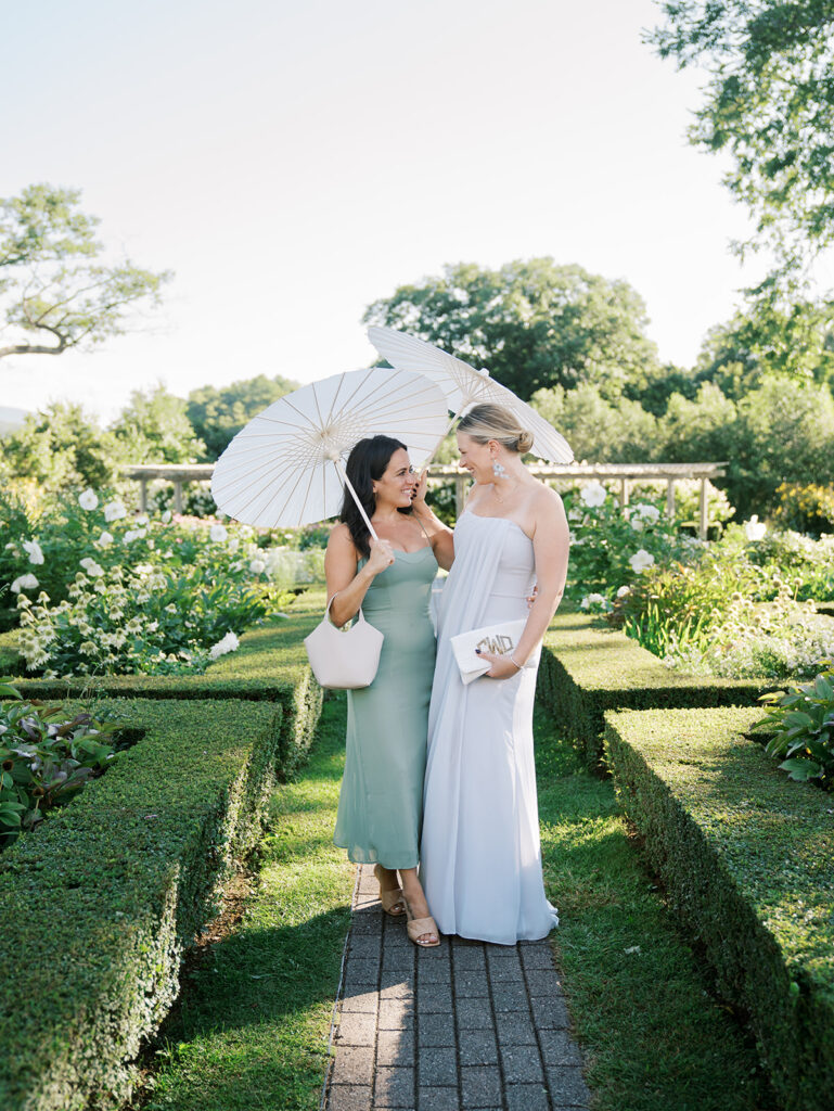 Guests under a parasol in the garden at their friend's Hildene wedding.