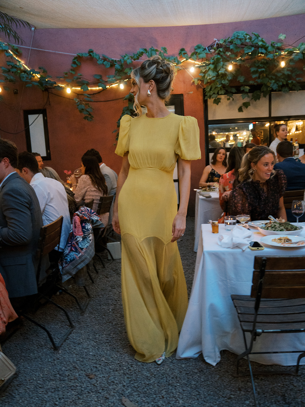 The bride walking through the guest tables while everyone is enjoying dinner. Mingling with guests.