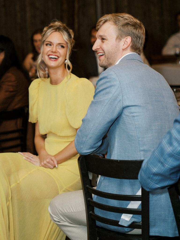 The bride and groom sharing a laugh during speeches at their Brooklyn Rehearsal Dinner.