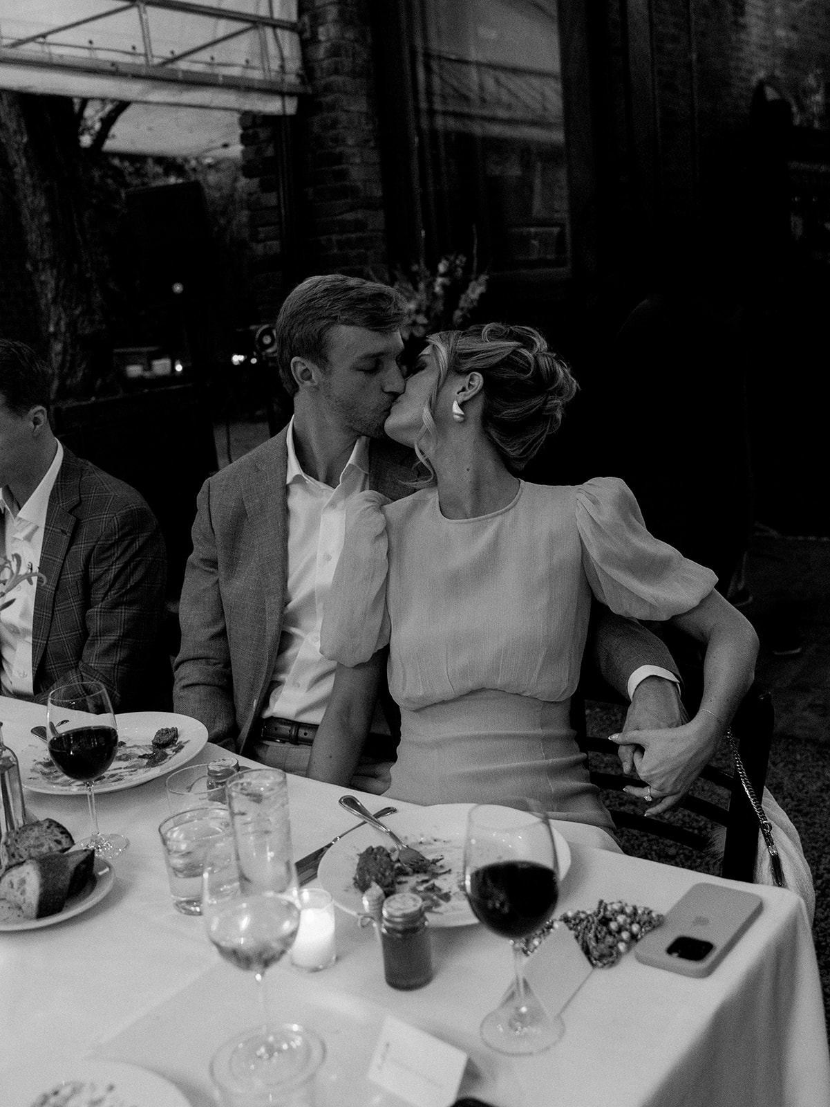 The bride and groom sharing a kiss during dinner.