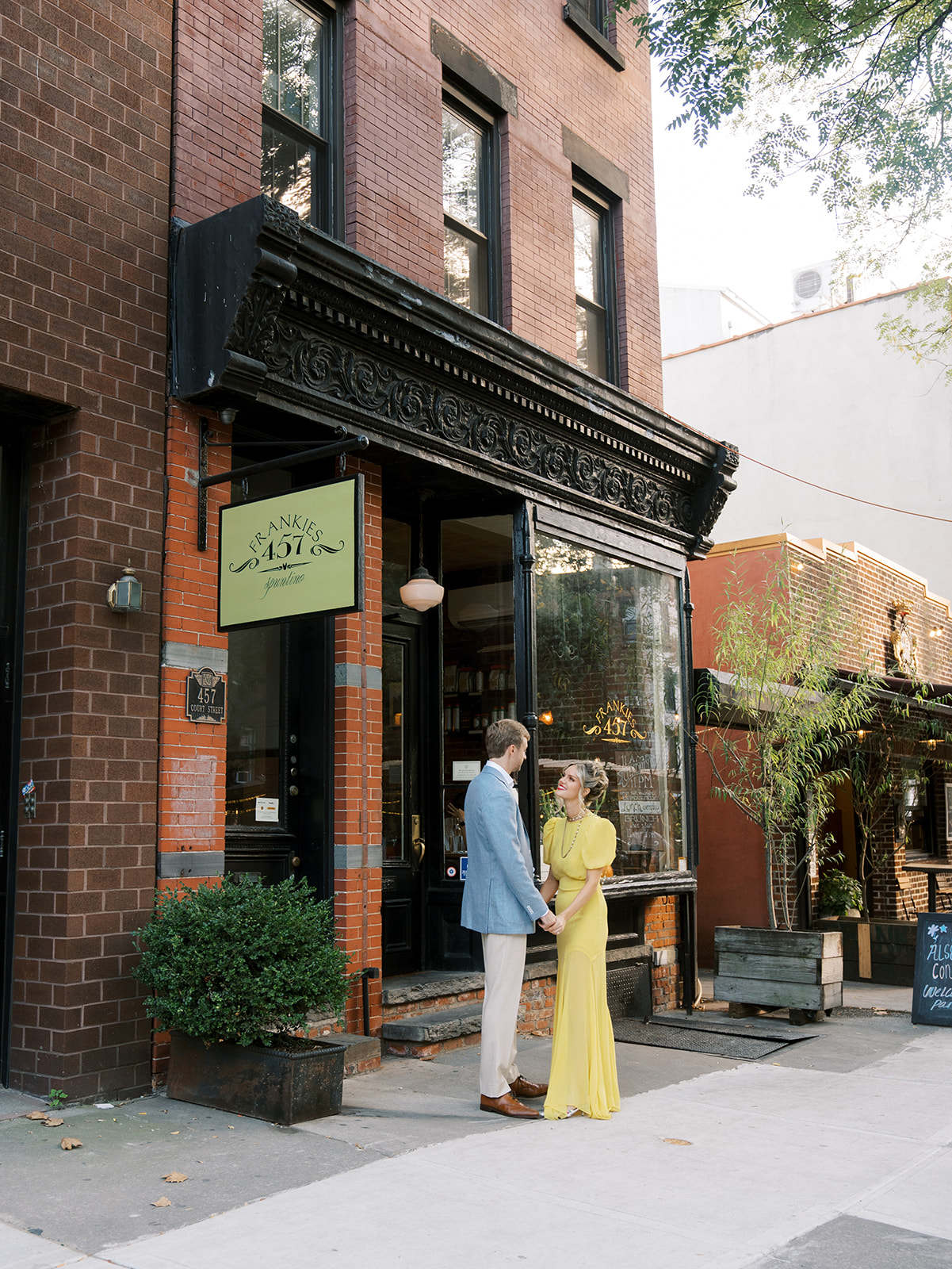 The bride and groom standing outside of Frankies Spuntino at their Brooklyn Rehearsal Dinner