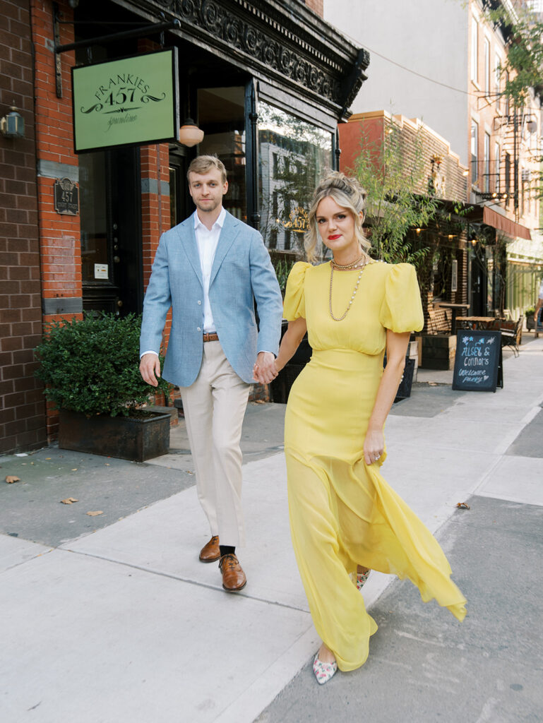 The bride and groom walking toward the camera for an action shot at Frankie's Spuntino in Brooklyn.