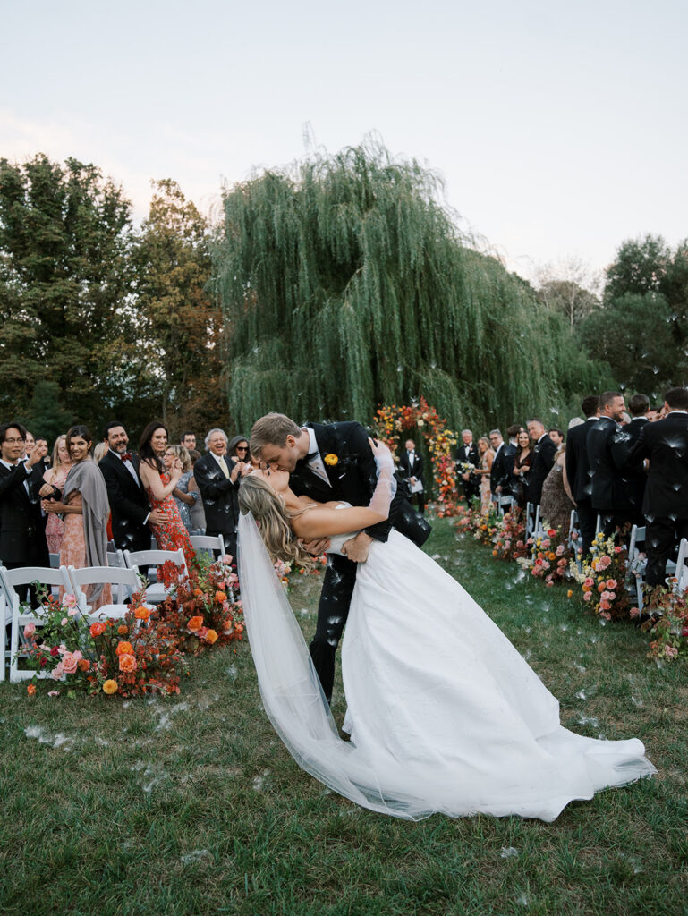 Bride and groom kissing during their recessional at their brooklyn botanic wedding